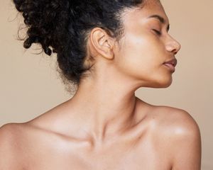 Woman with clear, glowing skin on face, neck, and shoulders