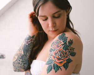 woman with arm tattoos standing in bathroom