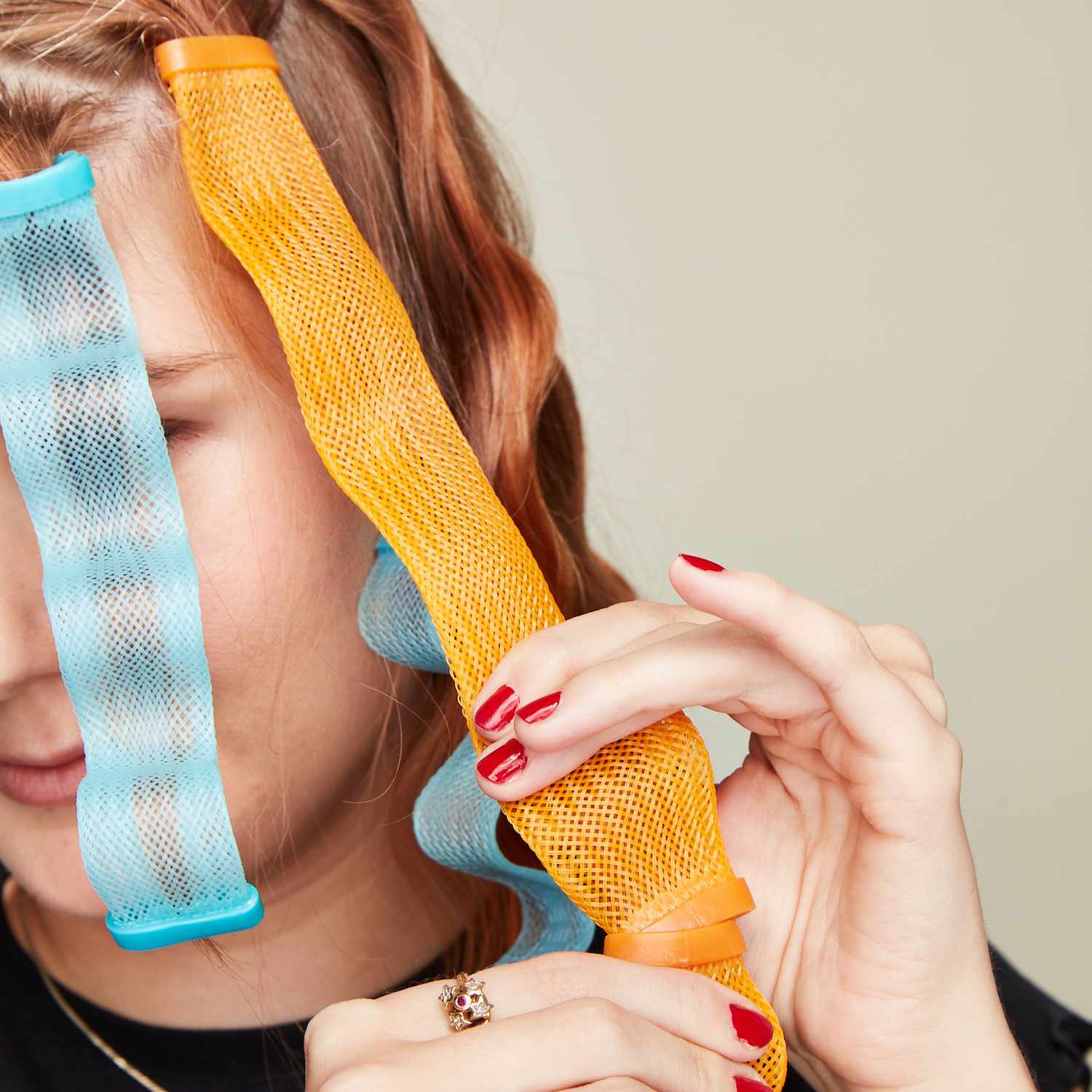 Byrdie editor Bella Cacciatore gently removes an orange waveformer from her hair