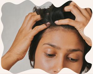 Up close of a woman's forehead with her fingers in her hair