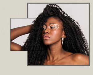 Woman with hair extensions, with her hand in her hair.