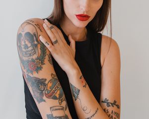 Tattooed woman with her hand on her shoulder