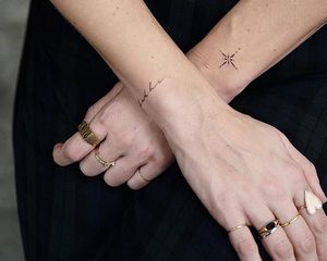 A person with two small tattoos on their wrists
