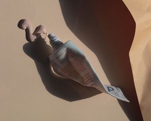 Squeezed tube of sunblock on an orange-cream background