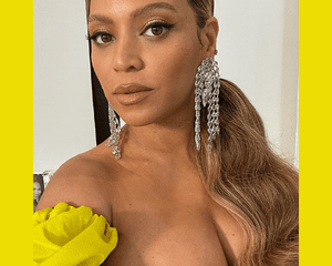 Beyonce with blonde highlights and a yellow dress