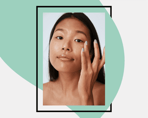 woman touching her eye with cream