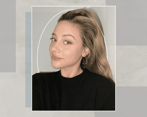 A Selfie of Lili Reinhart in a Black Shirt with Hoop Earrings, Dewy Skin, and Abstract Eye Makeup 