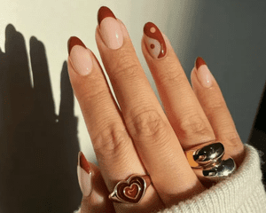 Manicure with brown French tips and yin/yang accent nail